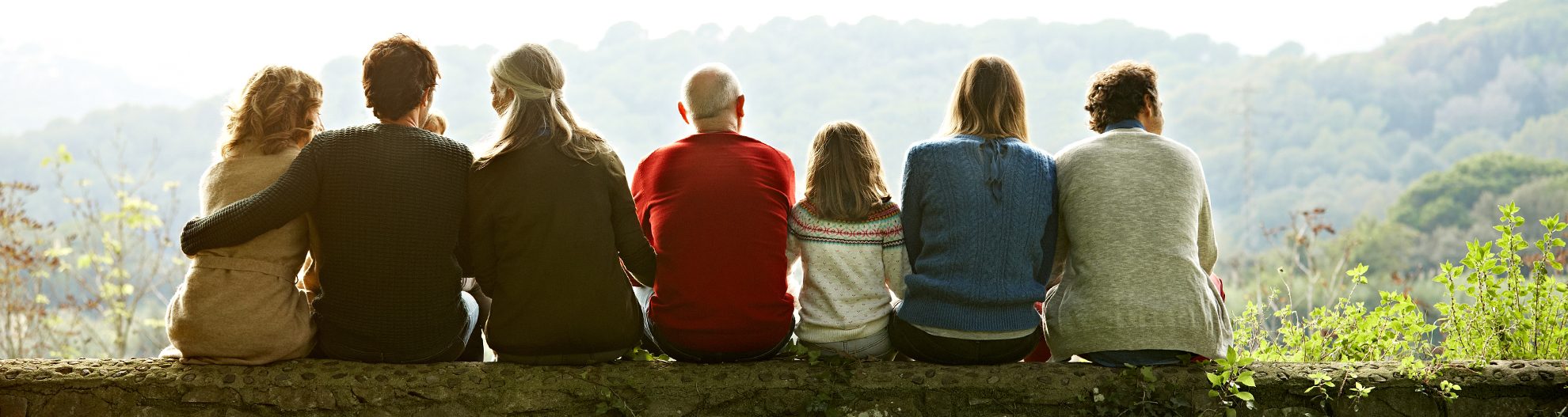 Multigenerational family sitting on a fallen tree