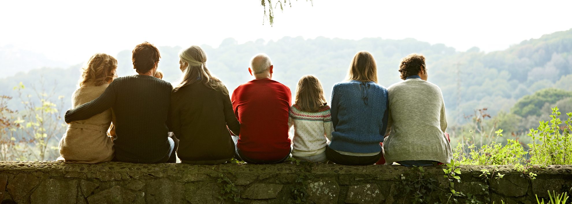 Multigenerational family sitting on a fallen tree